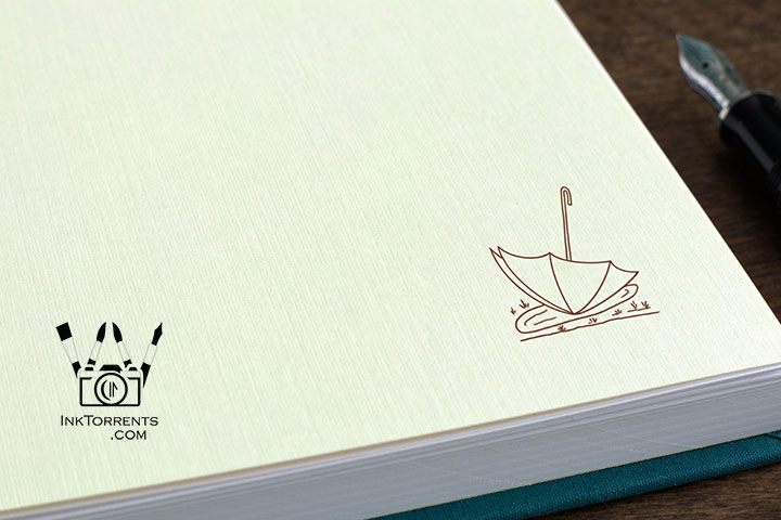 Close-up of linen endpaper with sepia umbrella art for Blue Hydrangeas in the Rain notebook — InkTorrents Graphics