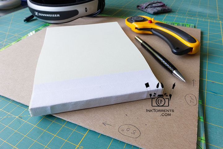 Finished text block with bookbinding tools and cover board on the work table — InkTorrents Graphics